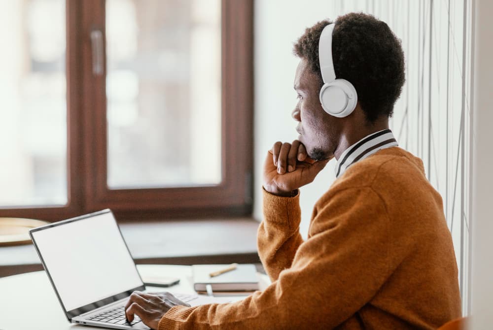 Tutor wearing headphones with a laptop, ready for an English lesson